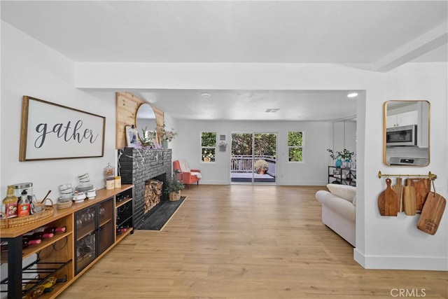 22384 Crest Forest Dr, Cedarpines Park, CA 92322 - living room with baseboards, light wood finished floors, and a large fireplace