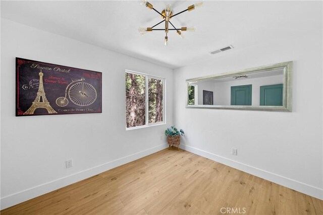 22384 Crest Forest Dr, Cedarpines Park, CA 92322 - unfurnished room featuring baseboards, a chandelier, and wood finished floors