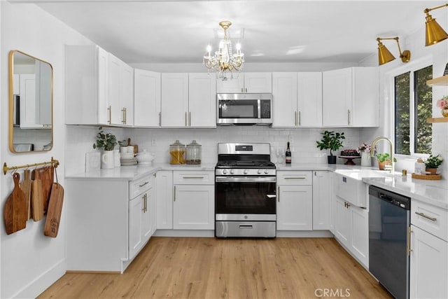 22384 Crest Forest Dr, Cedarpines Park, CA 92322 - kitchen featuring stainless steel appliances, a sink, light wood-type flooring, and decorative backsplash