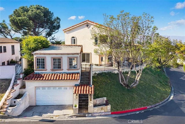 335 Montechico Dr, Monterey Park, CA 91754 - mediterranean / spanish house featuring stairs, stucco siding, a garage, concrete driveway, and a tiled roof