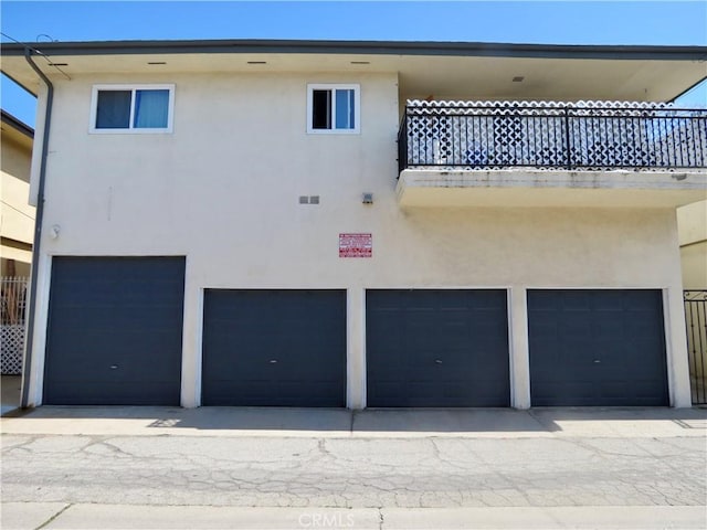 back of house with an attached garage and stucco siding