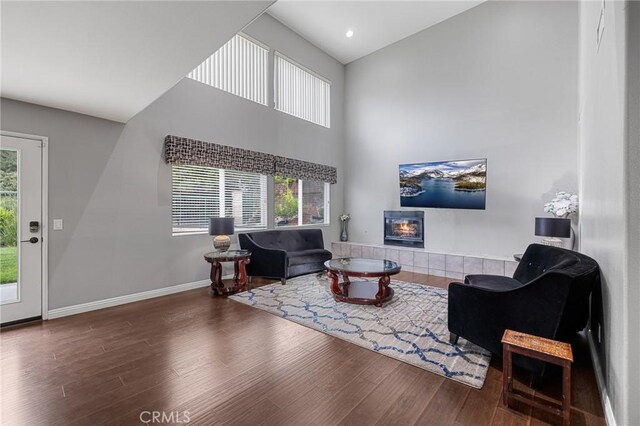 26426 Cardinal Dr, Canyon Country, CA 91387 - living room with wood finished floors, a tile fireplace, a towering ceiling, and baseboards