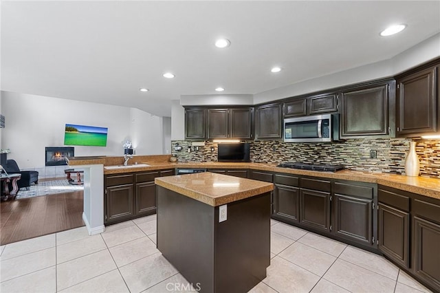 26426 Cardinal Dr, Canyon Country, CA 91387 - kitchen with appliances with stainless steel finishes, a peninsula, a kitchen island, decorative backsplash, and recessed lighting