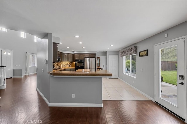 26426 Cardinal Dr, Canyon Country, CA 91387 - kitchen featuring freestanding refrigerator, dark brown cabinetry, a peninsula, light wood finished floors, and recessed lighting