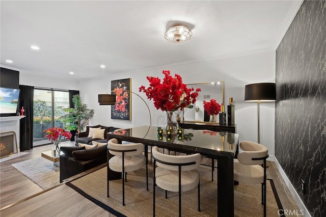 5100 Riverton Ave Unit 14, North Hollywood, CA 91601 - dining room featuring wood finished floors, recessed lighting, a warm lit fireplace, and ornamental molding