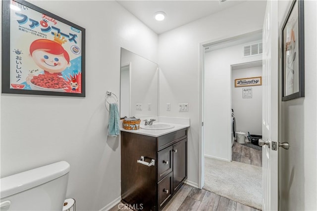 7155 Citrus Ave Unit 315, Fontana, CA 92336 - bathroom with wood finished floors, toilet, vanity, and baseboards