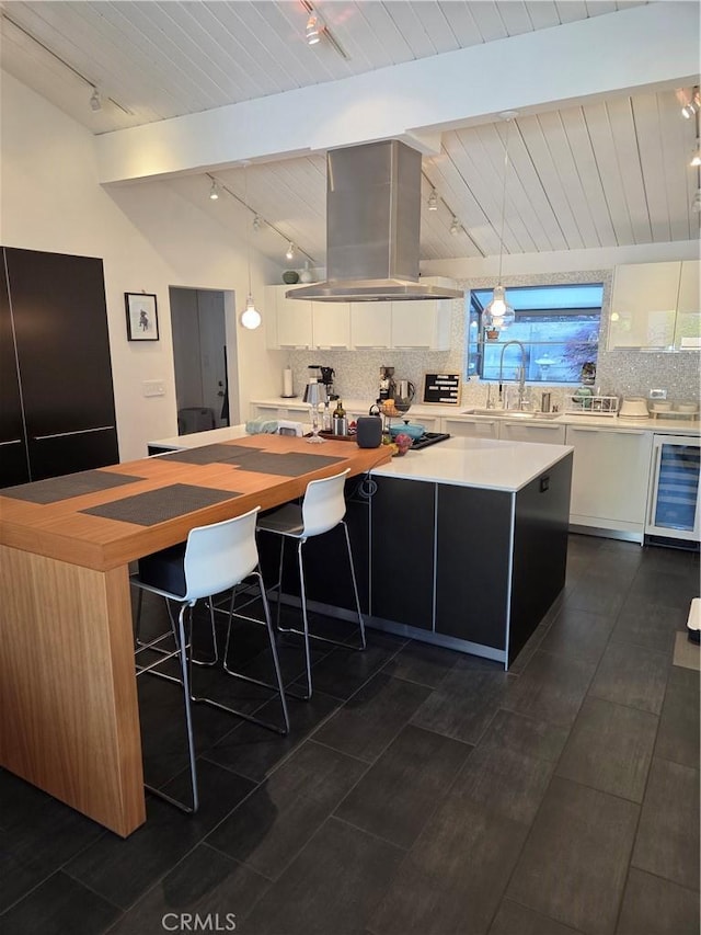 28715 Crestridge Rd, Rancho Palos Verdes, CA 90275 - kitchen featuring track lighting, island exhaust hood, wine cooler, white cabinetry, and decorative backsplash