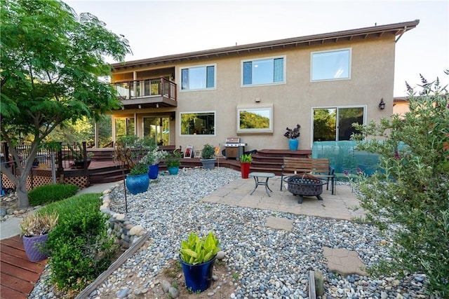 5145 Northfork Pl, Paso Robles, CA 93446 - rear view of house featuring a fire pit, a balcony, stucco siding, a deck, and a patio