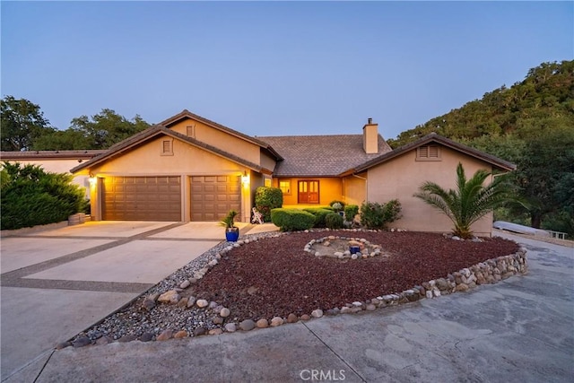 5145 Northfork Pl, Paso Robles, CA 93446 - view of front facade featuring a chimney, stucco siding, an attached garage, and driveway