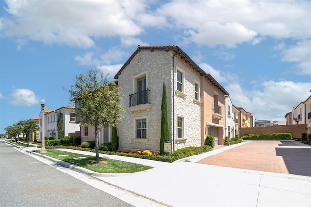 124 Trumpet Flower, Irvine, CA 92618 - view of home's exterior with a residential view, stone siding, and a balcony