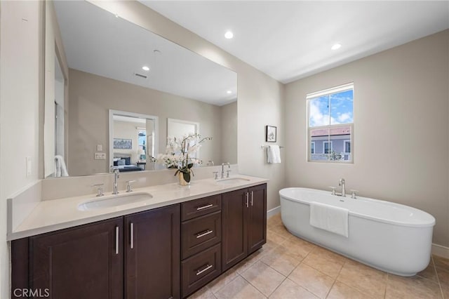 124 Trumpet Flower, Irvine, CA 92618 - ensuite bathroom with a freestanding bath, double vanity, tile patterned flooring, baseboards, and recessed lighting