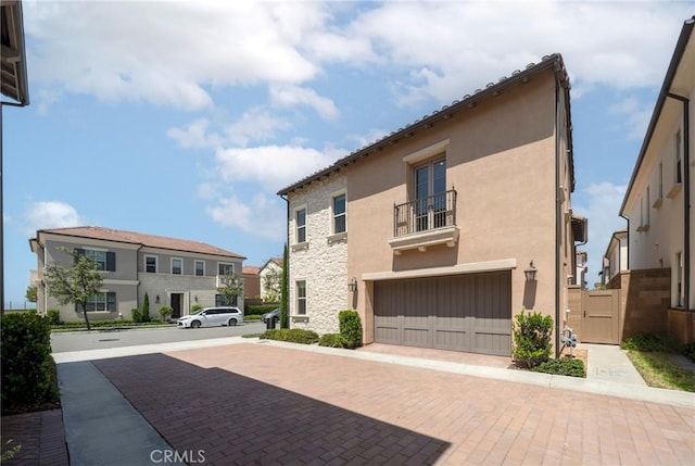 124 Trumpet Flower, Irvine, CA 92618 - view of front of home featuring a balcony, an attached garage, stone siding, stucco siding, and a residential view