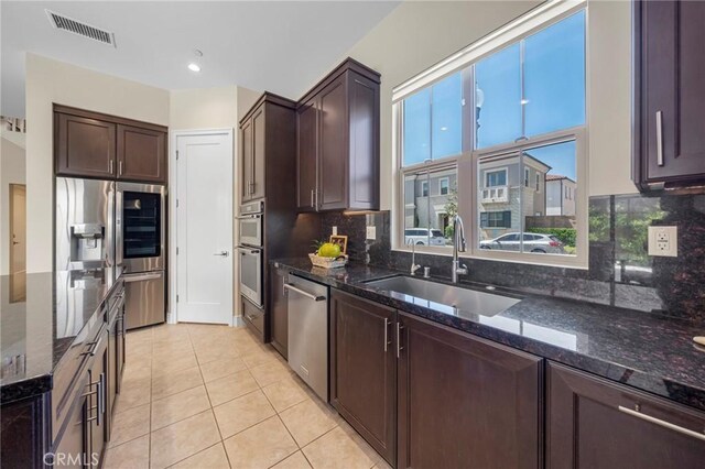 124 Trumpet Flower, Irvine, CA 92618 - kitchen with stainless steel appliances, a sink, dark stone counters, and backsplash