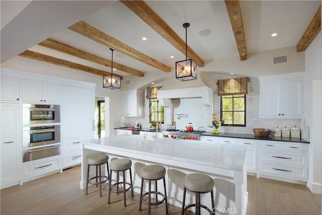 17 Pacific Ridge Pl, Dana Point, CA 92629 - kitchen featuring a warming drawer, backsplash, light wood-type flooring, white cabinets, and a breakfast bar area