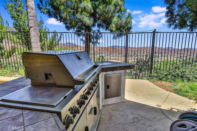 view of patio / terrace with fence and a grill