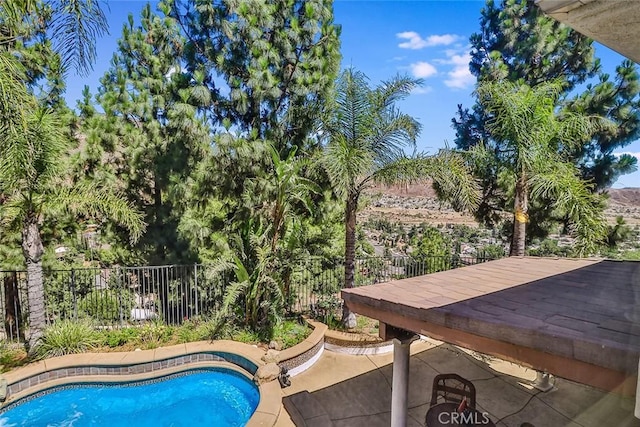 view of swimming pool with fence and a patio