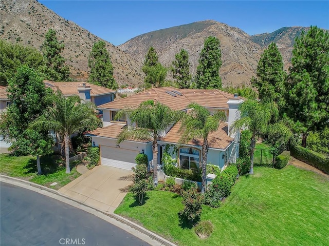 view of front of property with driveway, a mountain view, an attached garage, and stucco siding