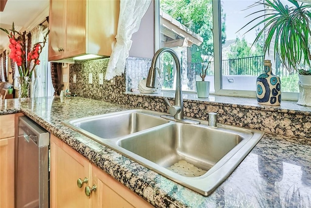 kitchen view of a sink, stainless steel dishwasher, tasteful backsplash, and light brown cabinets