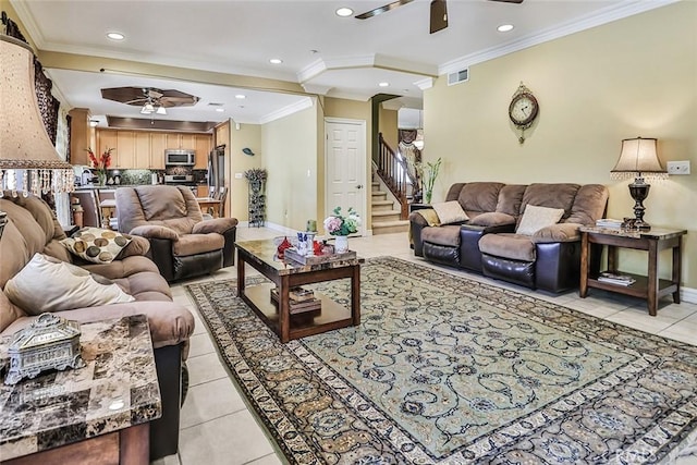 living room with a ceiling fan, crown molding, light tile patterned floors, baseboards, and stairway