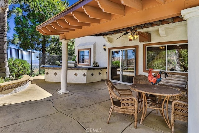 view of patio with fence, a ceiling fan, and area for grilling