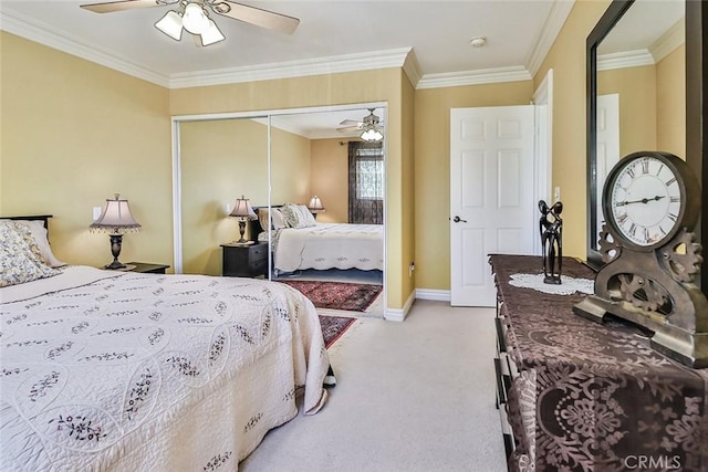 bedroom with a closet, light carpet, crown molding, baseboards, and ceiling fan