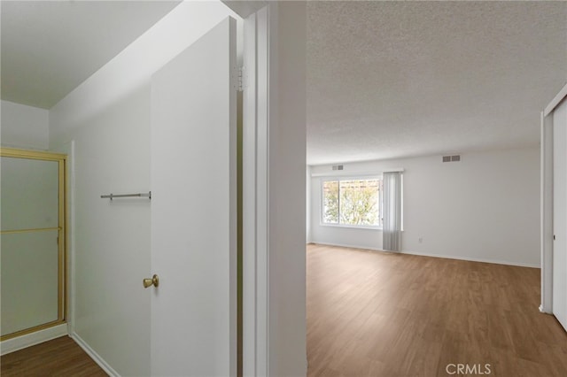 hallway with wood finished floors and baseboards