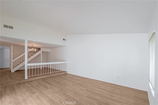 below grade area with light wood-style flooring, a chandelier, and plenty of natural light