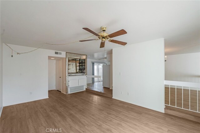 unfurnished living room with wood finished floors and ceiling fan