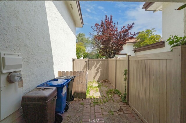 view of side of home featuring stucco siding and fence