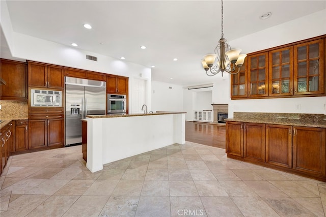 2117 Brittany Park Rd, Camarillo, CA 93012 - kitchen with built in appliances, a chandelier, dark stone counters, recessed lighting, and glass insert cabinets