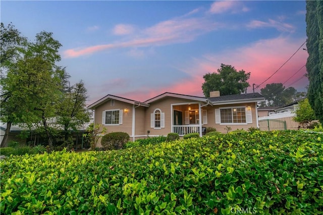 ranch-style house featuring fence and a porch