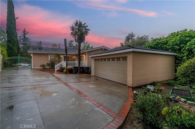 view of front facade featuring a gate, a garage, and driveway