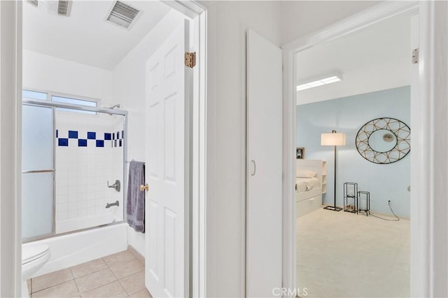 bathroom with enclosed tub / shower combo, toilet, and tile patterned floors