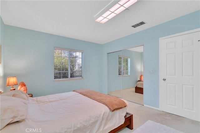 bedroom with carpet floors, multiple windows, and a closet