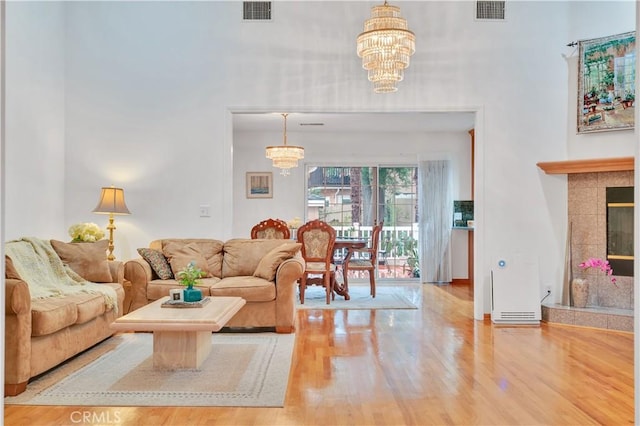 4745 Dunsmore Ave, La Crescenta, CA 91214 - living room with a chandelier, wood finished floors, a towering ceiling, and a tile fireplace