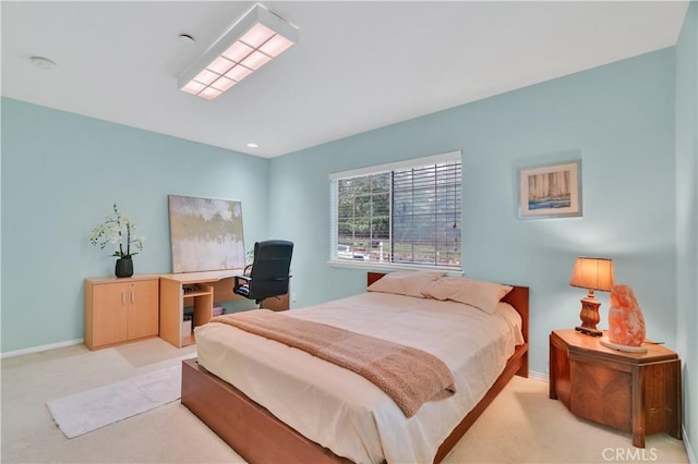bedroom with light colored carpet and baseboards