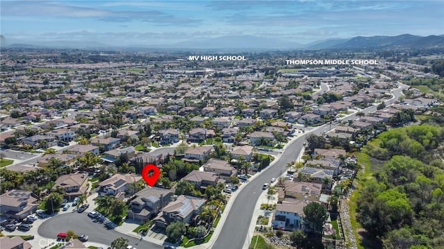 aerial view of property's location featuring nearby suburban area and a mountain backdrop