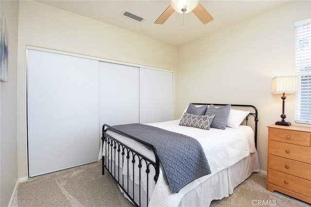 carpeted bedroom featuring a closet, ceiling fan, and baseboards