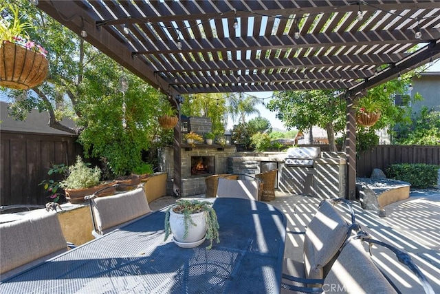 view of patio / terrace featuring an outdoor stone fireplace, outdoor dining space, fence, and a pergola