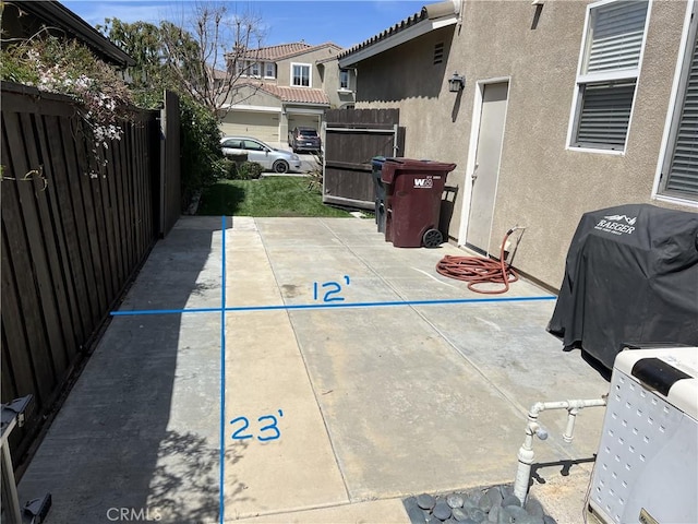 view of patio featuring fence and a grill