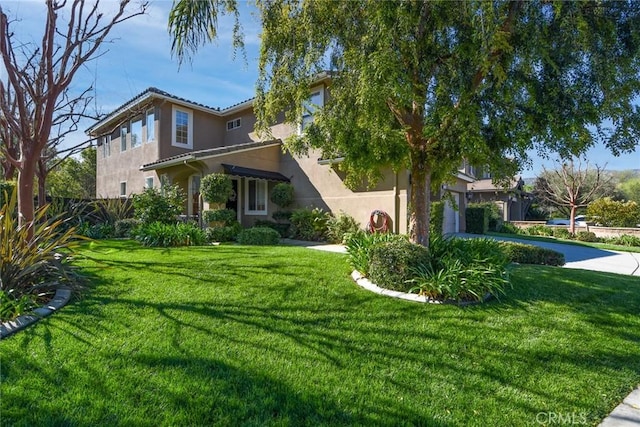 view of front of home with stucco siding, driveway, and an attached garage