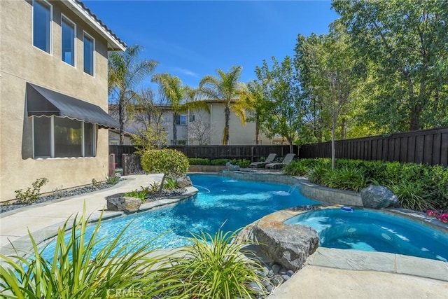 view of swimming pool featuring a fenced backyard and a pool with connected hot tub