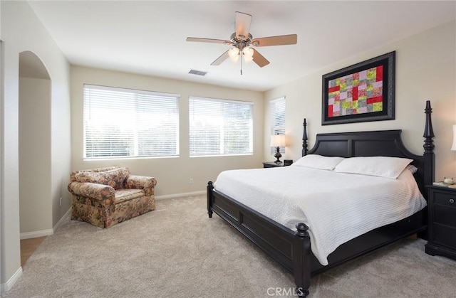 bedroom featuring light carpet, baseboards, and ceiling fan