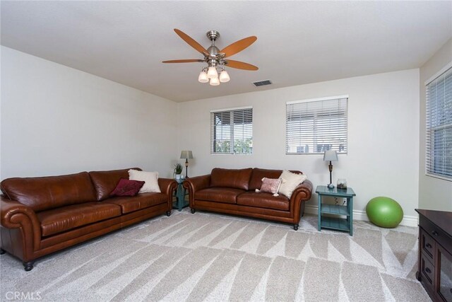 living room with carpet floors, a ceiling fan, and baseboards
