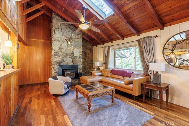 26220 Pine Dell Rd, Idyllwild, CA 92549 - living area featuring a wood stove, wood finished floors, wooden ceiling, ceiling fan, and a skylight