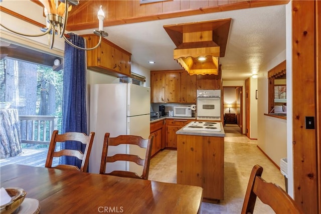 26220 Pine Dell Rd, Idyllwild, CA 92549 - kitchen with white appliances, brown cabinets, a kitchen island, and light countertops