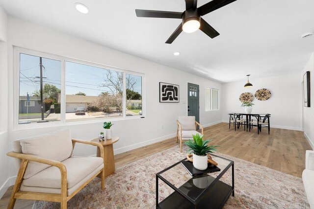 living room featuring plenty of natural light, light wood-style floors, baseboards, recessed lighting, and a ceiling fan