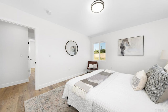bedroom featuring wood finished floors and baseboards