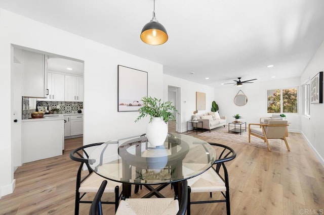 dining space with a ceiling fan, light wood finished floors, baseboards, and recessed lighting