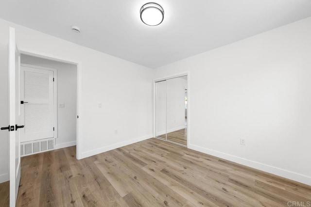 empty room featuring baseboards, light wood-style floors, and a smoke detector